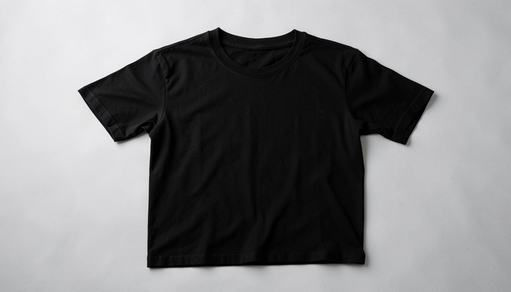 Black short-sleeve t-shirt laid flat on light grey background, clean minimal look